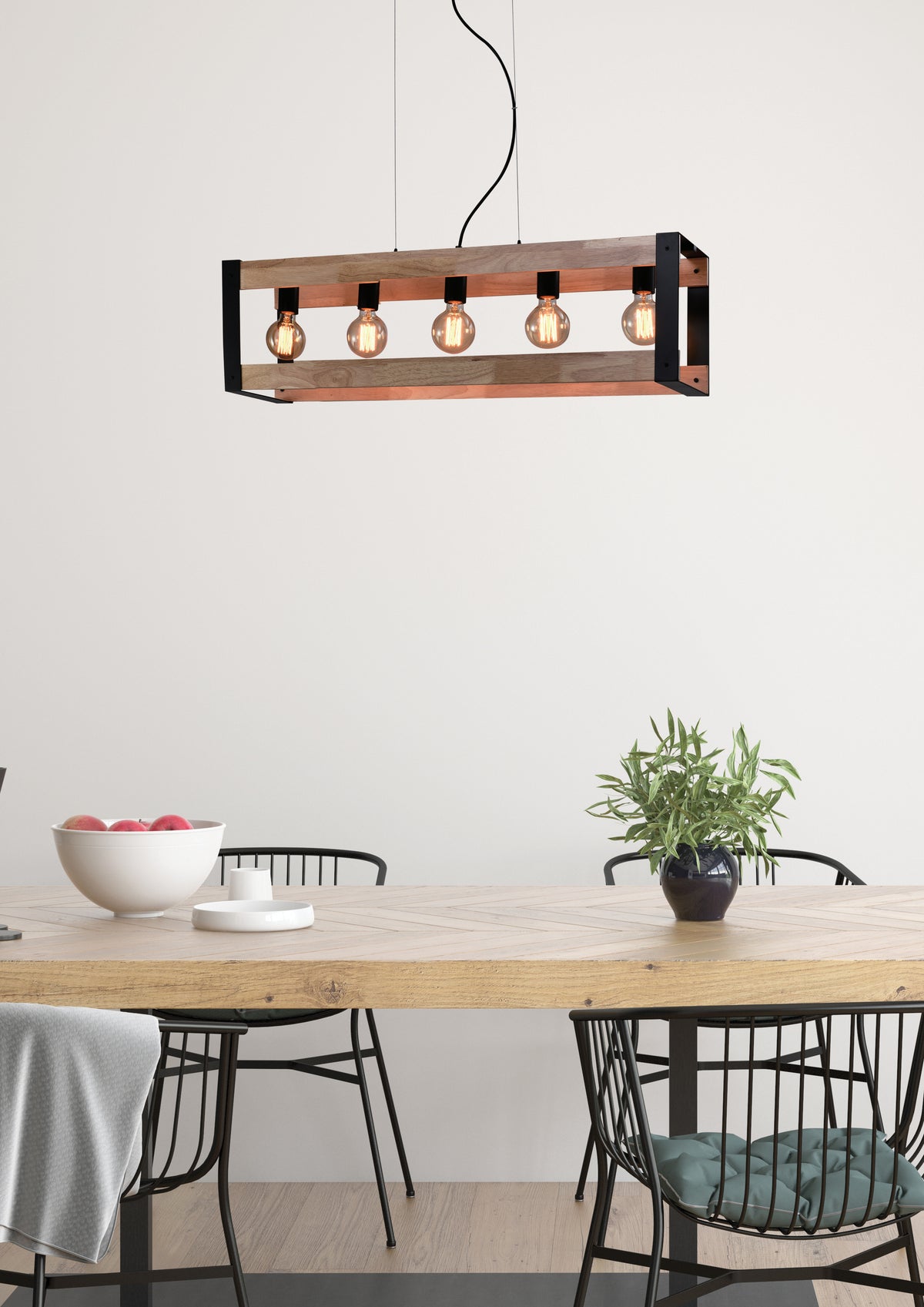 Suspension allumée au-dessus d'une table en bois dans une salle à manger lumineuse.