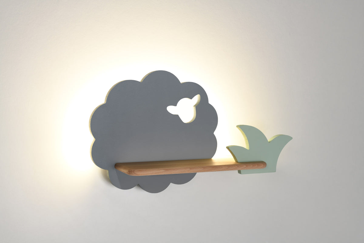 Vue rapprochée de l'applique éclairée avec étagère en bois et oiseau vert.