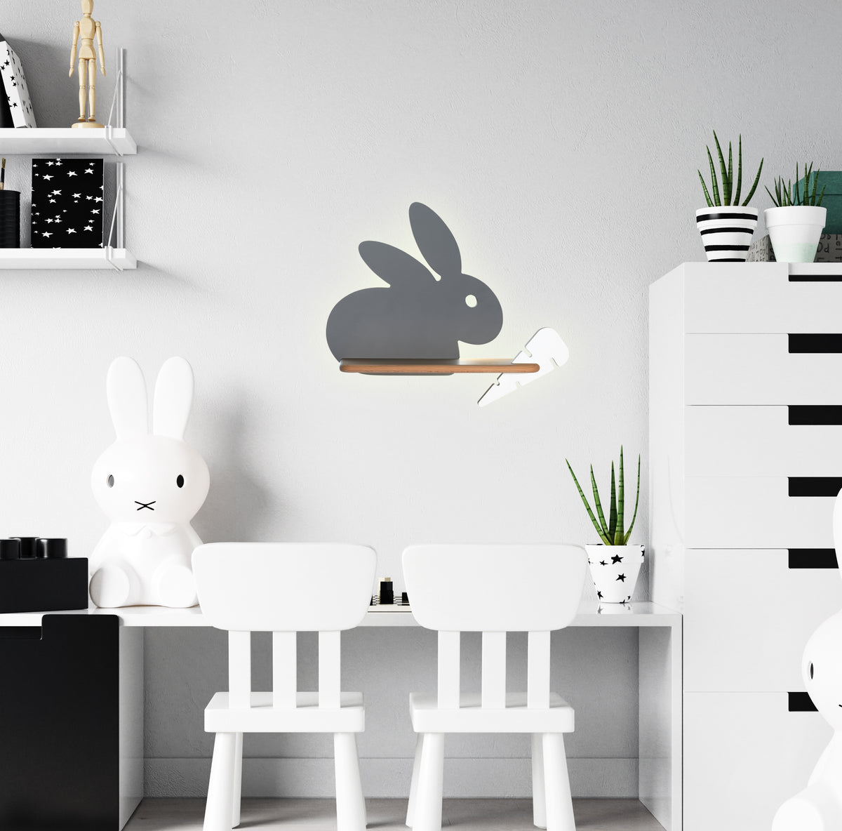 Mise en ambiance dans une chambre d'enfant blanche, applique lapin fixée au mur au-dessus du bureau