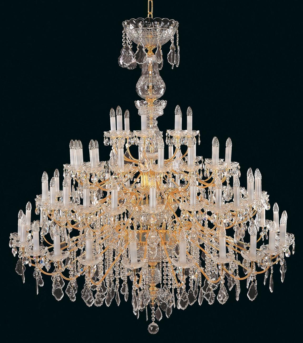 Lustre en cristal doré à nombreux bras, photographié de face sur fond noir