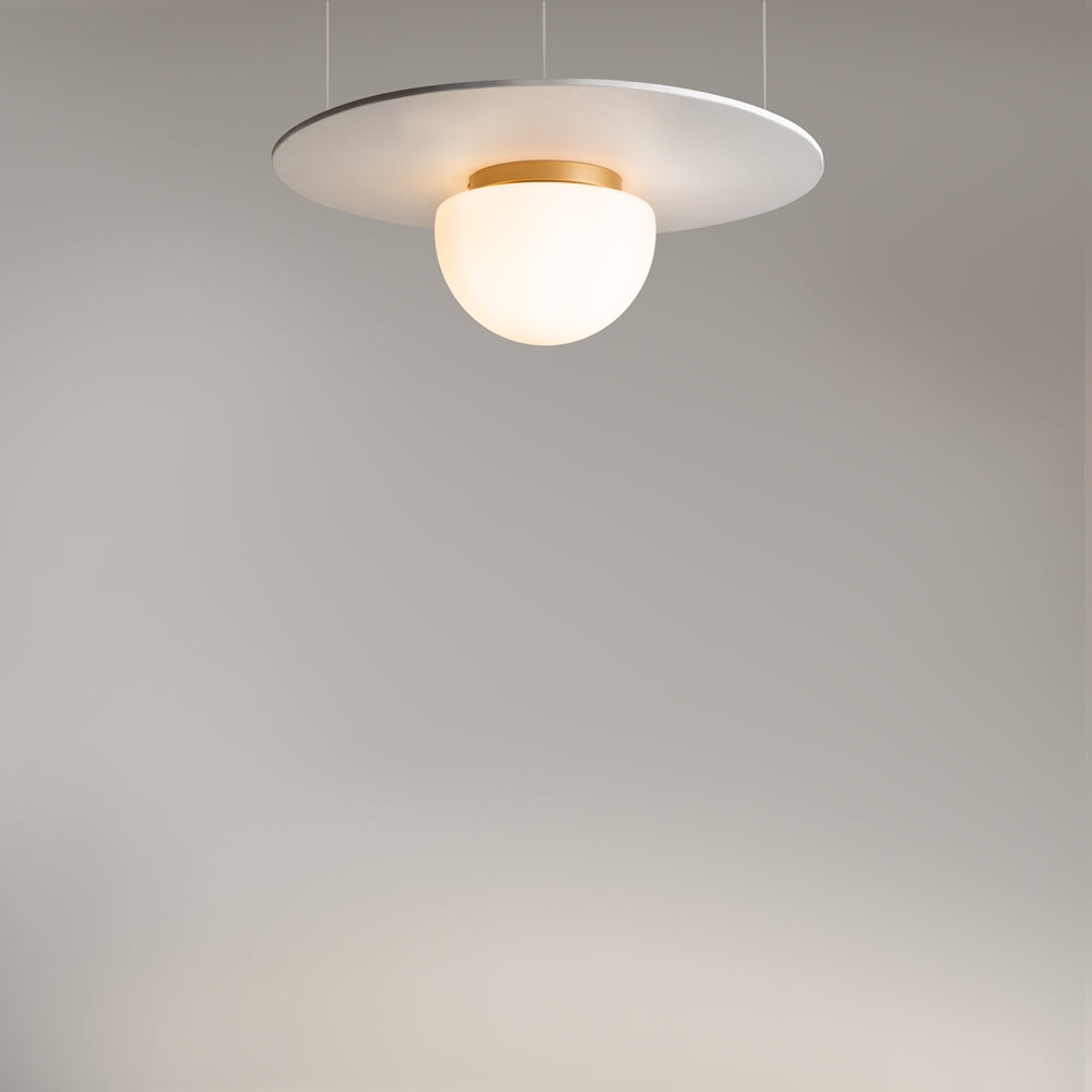 Vue en situation : luminaire suspendu par câbles sous un grand disque blanc.
