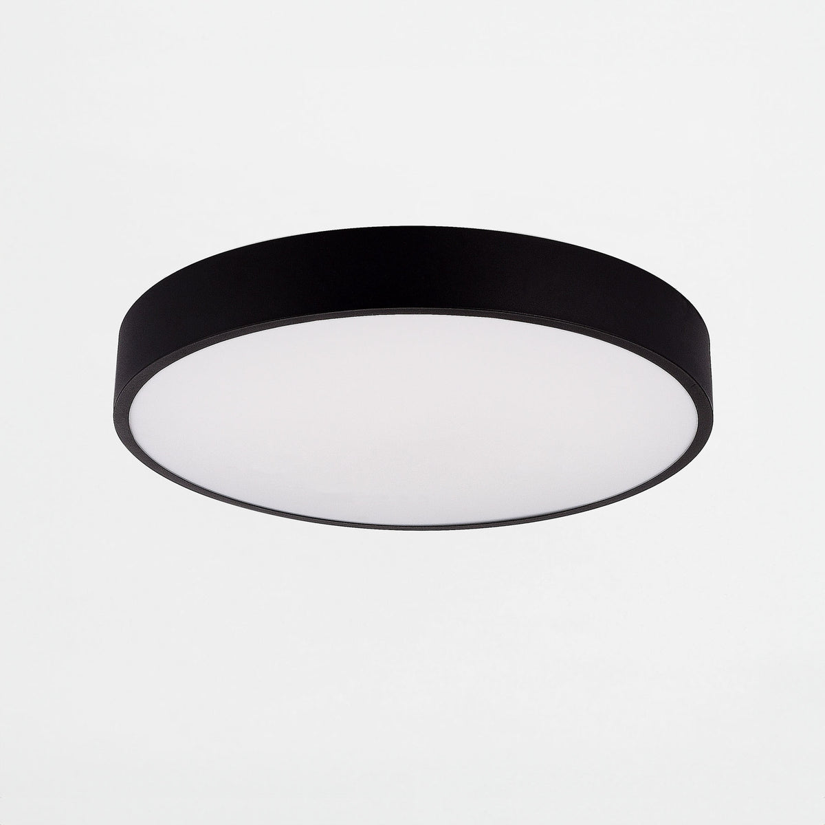 Plafonnier rond vu de face, cerclage noir mat et large diffuseur blanc opalin