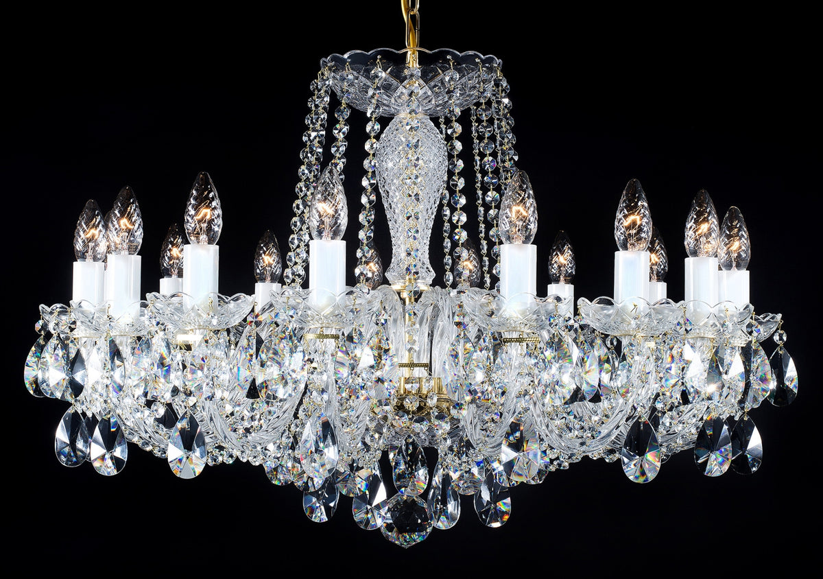 Lustre en cristal à plusieurs bras, suspendu, avec pendants et chaînettes de cristal, sur fond noir.