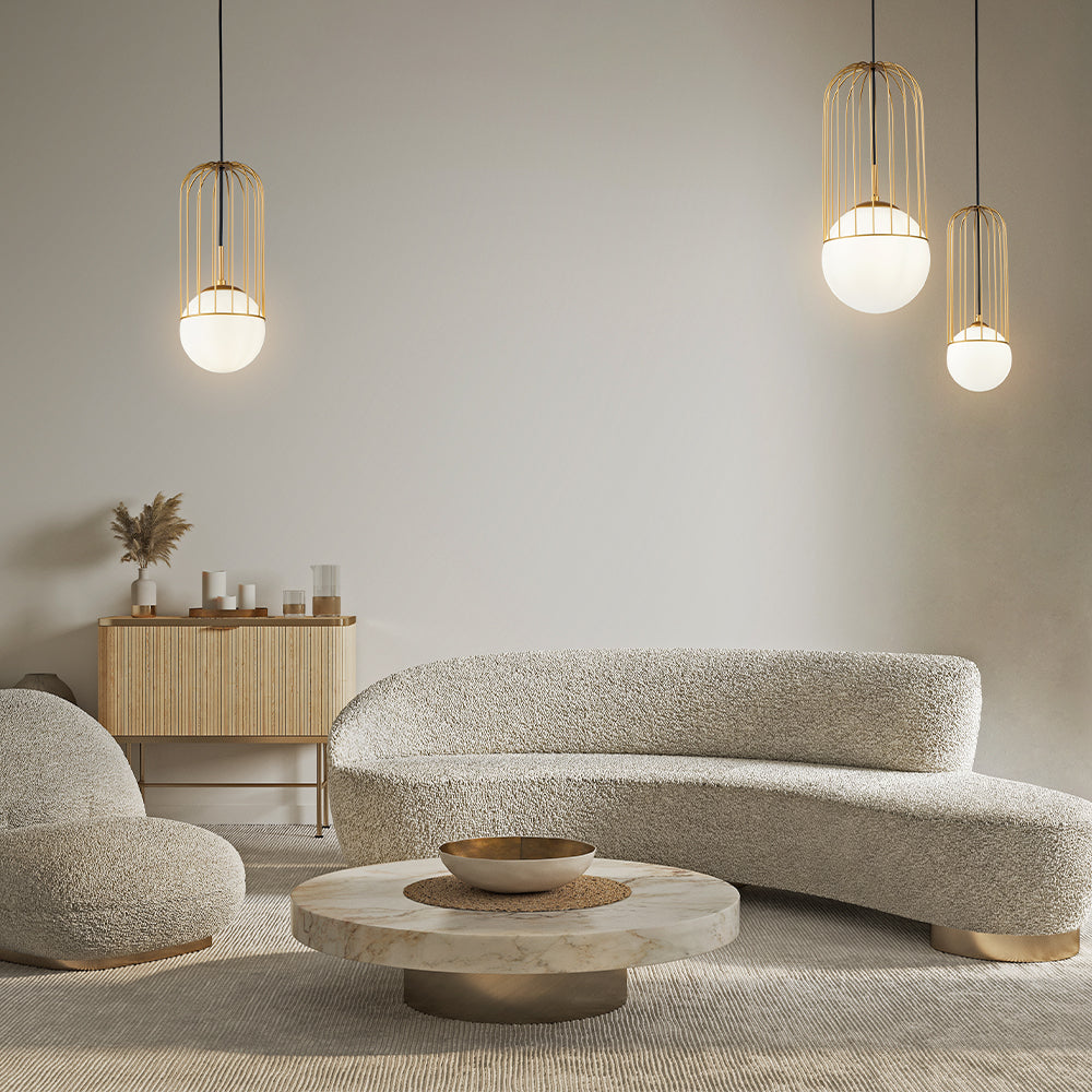 Mise en ambiance salon moderne avec trois suspensions dorées allumées