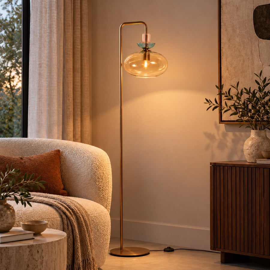 Lampadaire allumé près d’un canapé bouclé, rideau clair et meuble en bois strié.