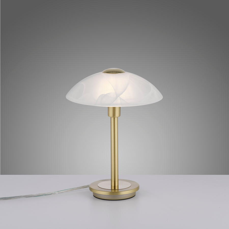Lampe allumée posée sur surface claire, câble d'alimentation visible sur le côté