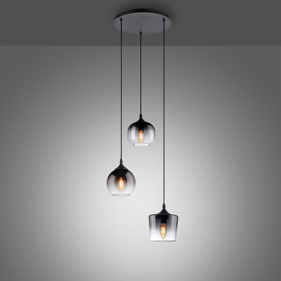 Luminaire suspendu noir à trois lumières allumées sur fond gris dégradé