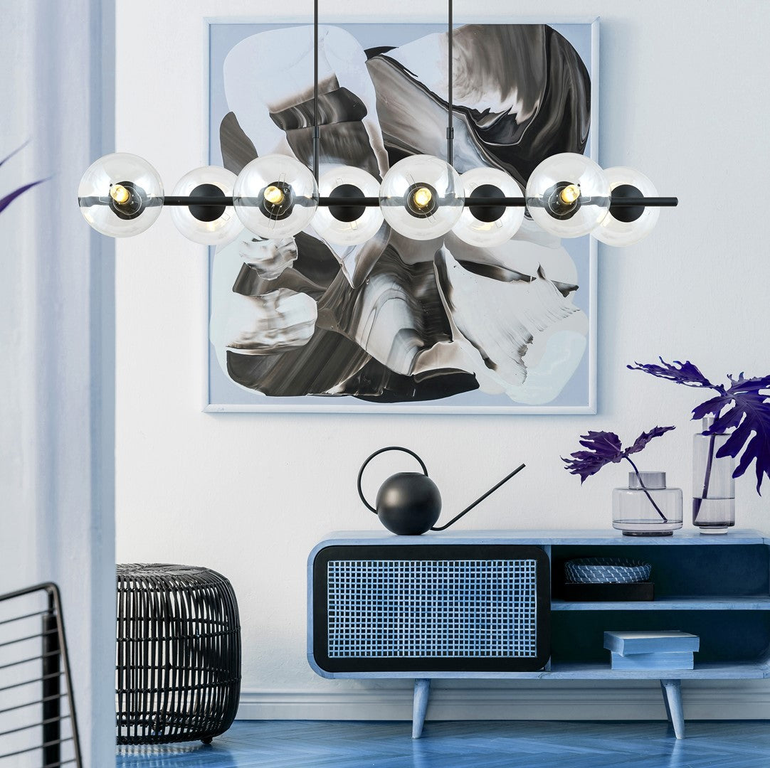 Suspension allumée au-dessus d'un meuble bleu dans un intérieur clair