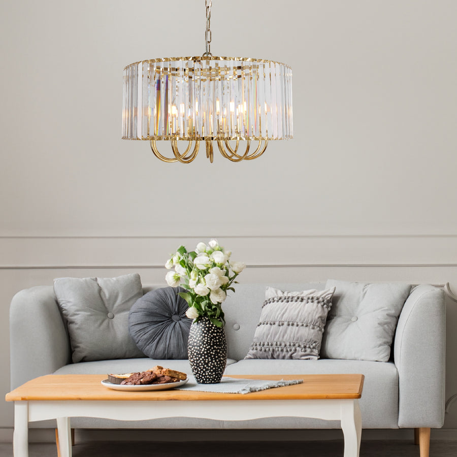 Suspension dorée installée au-dessus d'une table basse devant un canapé gris clair