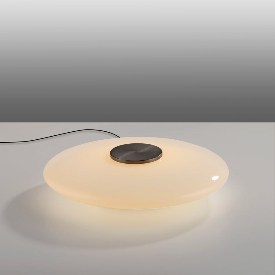 Vue en plongée montrant le câble noir et la lumière diffusée par le verre opalin.