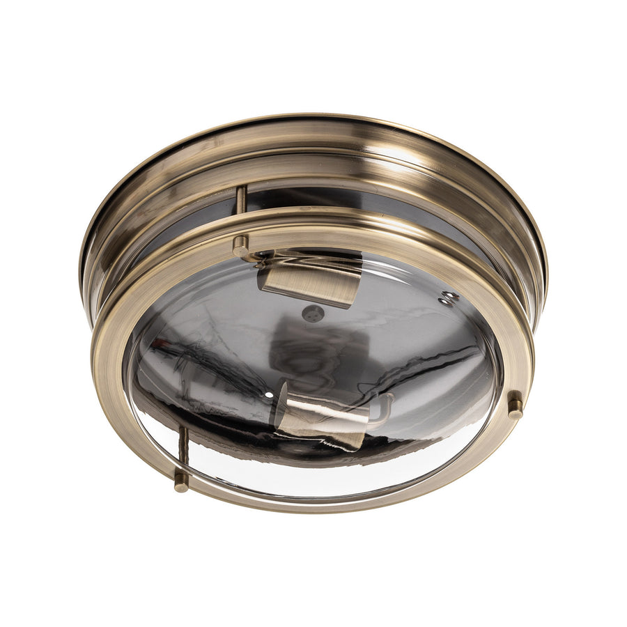 Vue de dessous du luminaire rond, verre transparent et deux douilles en laiton.