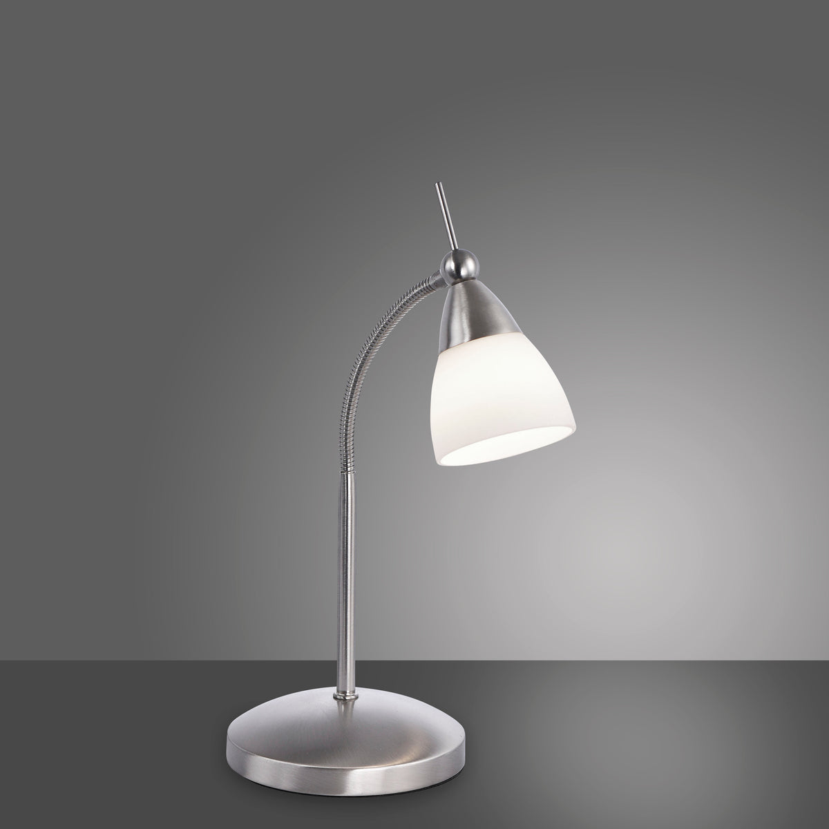 Lampe de bureau en acier et verre blanc, présentée de trois quarts sur fond gris.