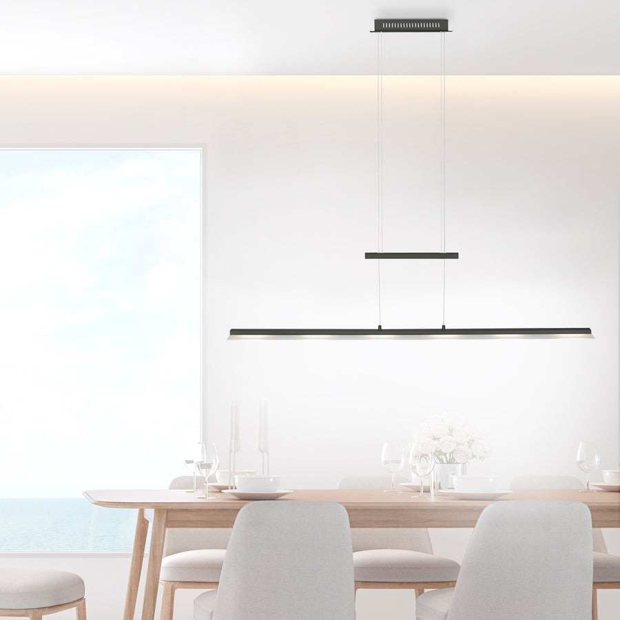 Au-dessus d'une table à manger en bois clair, suspension linéaire allumée dans un intérieur épuré.