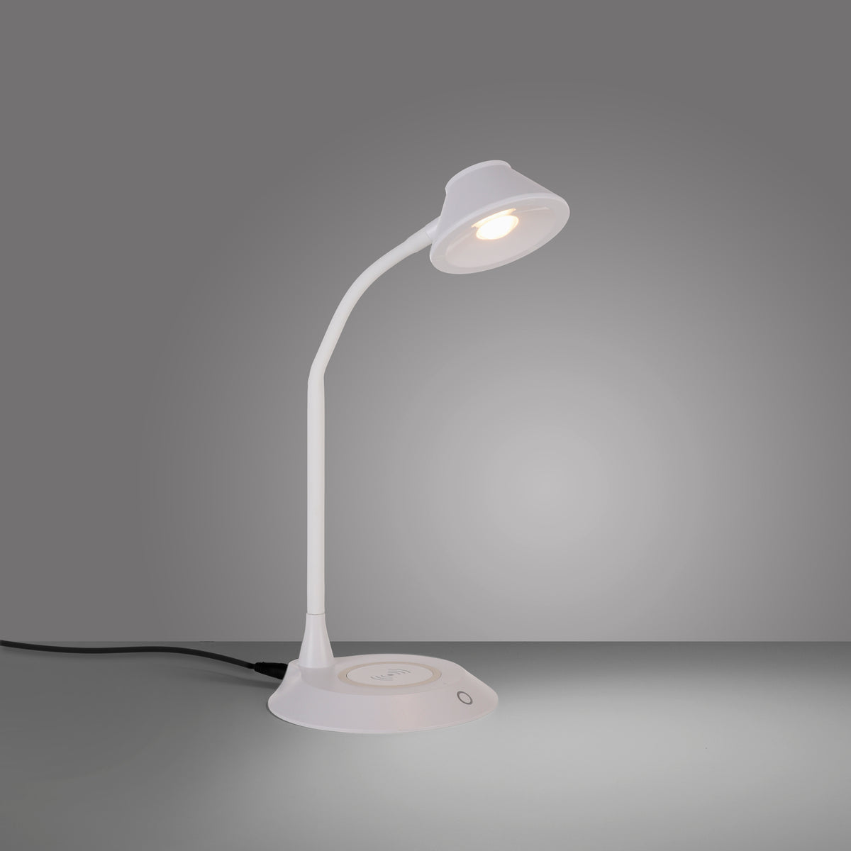 Vue de profil de la lampe allumée sur fond gris, socle et câble visibles.