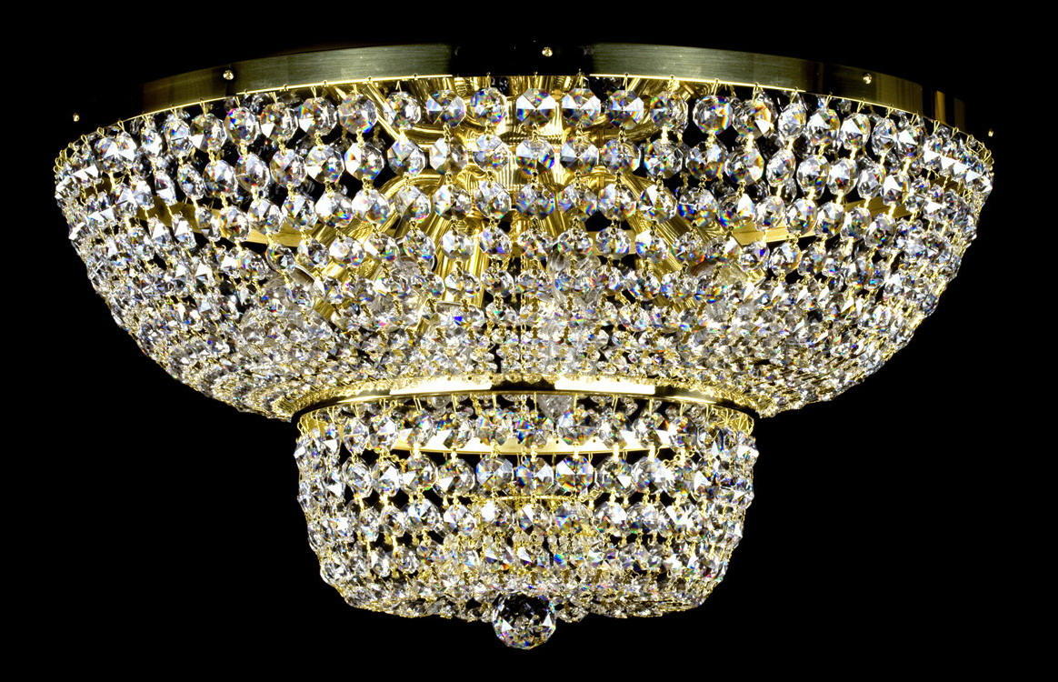 Plafonnier deux niveaux en cristal et métal doré, vu de face sur fond noir.