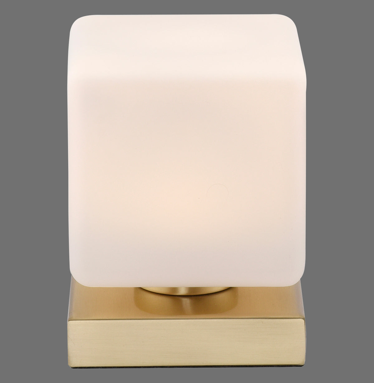 Vue de face de la lampe à poser, abat-jour carré en verre et base en laiton.
