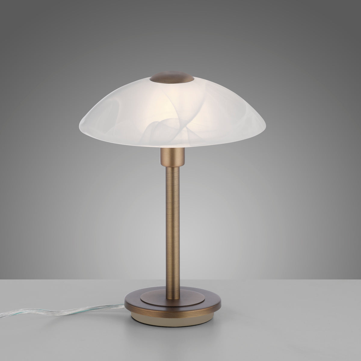Vue de face sur fond gris, câble d'alimentation visible au pied de la lampe