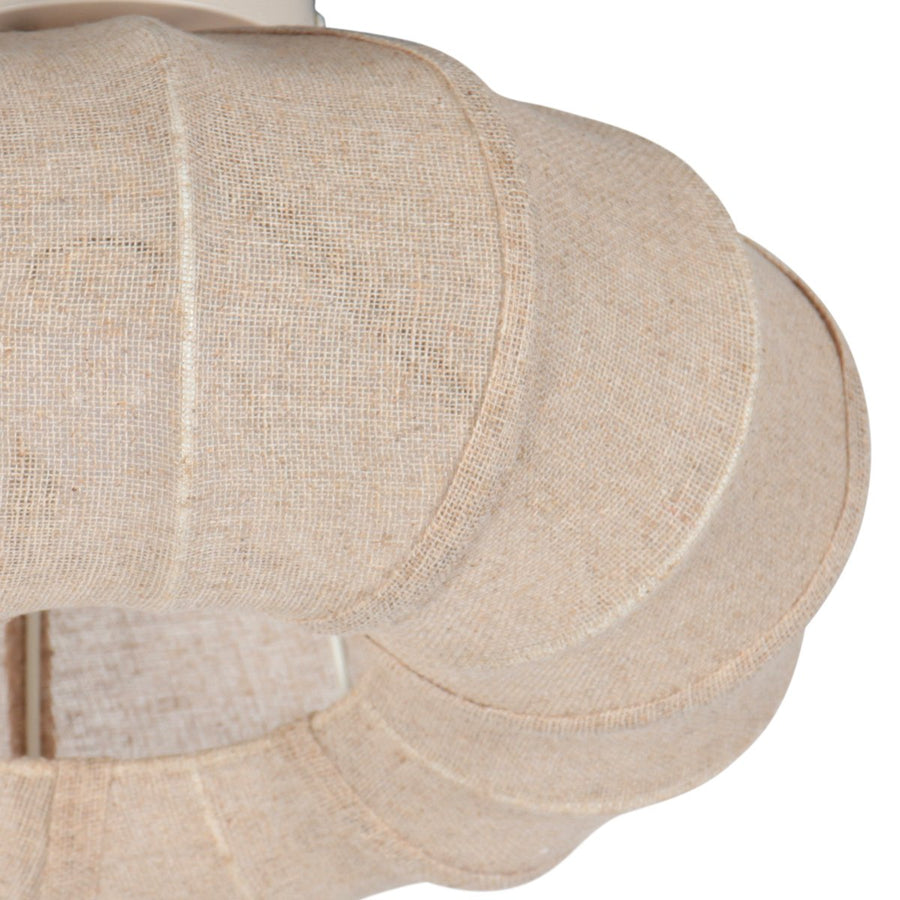 Gros plan sur le bord godronné et la texture du tissu beige du luminaire.