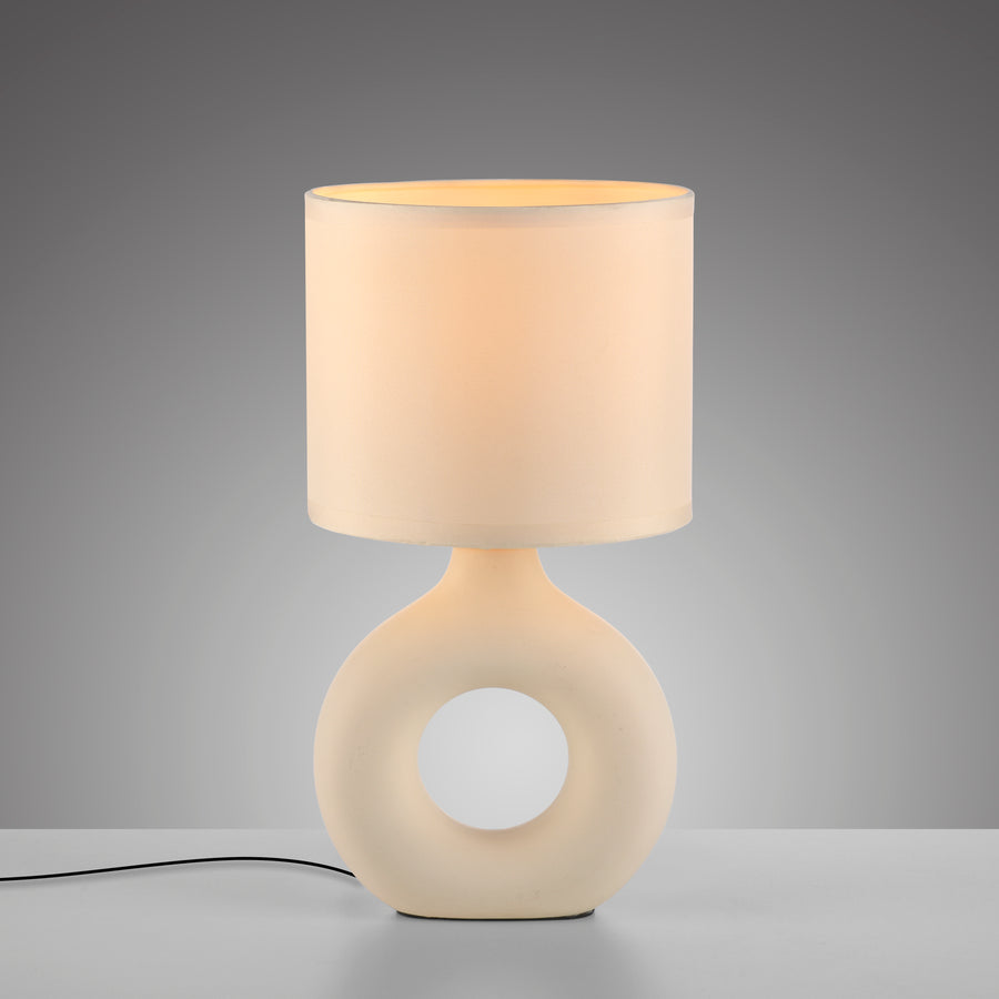 Vue de face sur fond gris dégradé, lampe beige avec câble noir visible au sol.