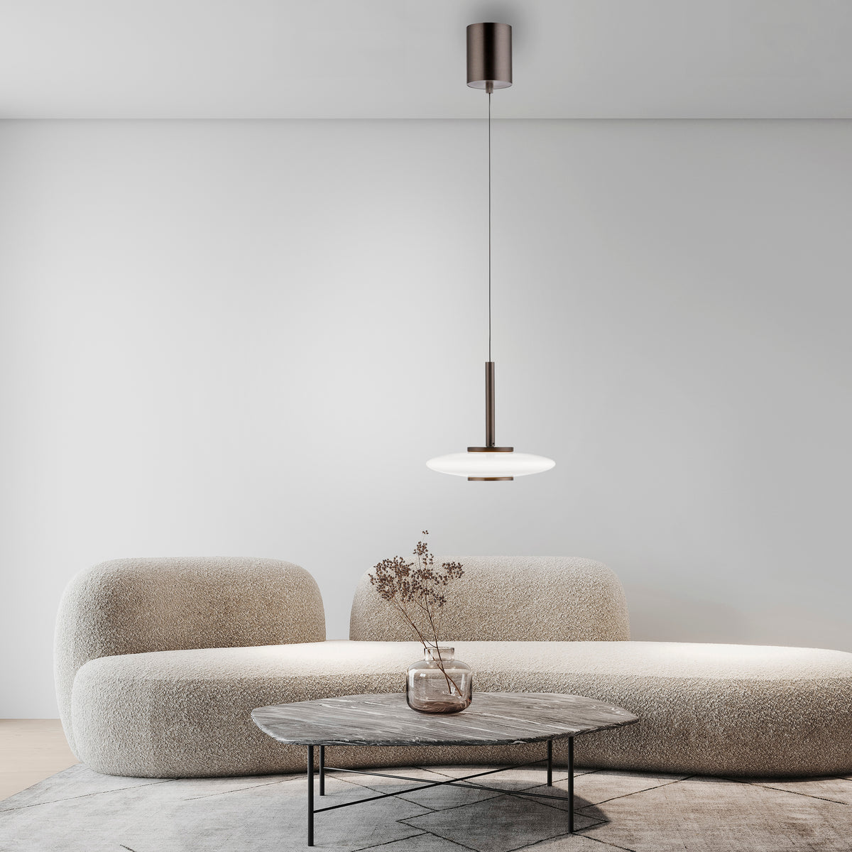 Mise en ambiance dans un salon épuré, suspension allumée au-dessus d'une table basse