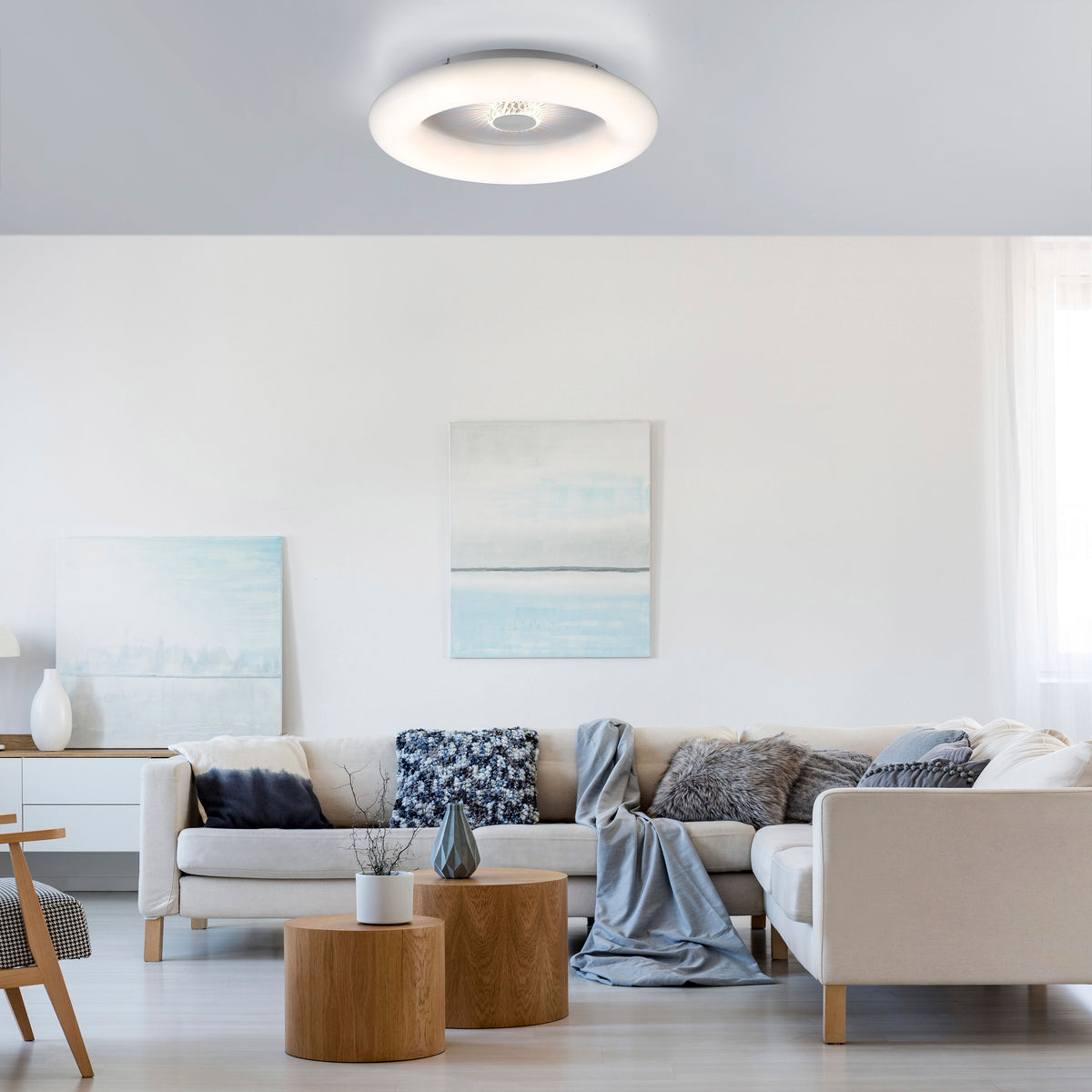Plafonnier blanc installé au plafond dans un salon contemporain lumineux.
