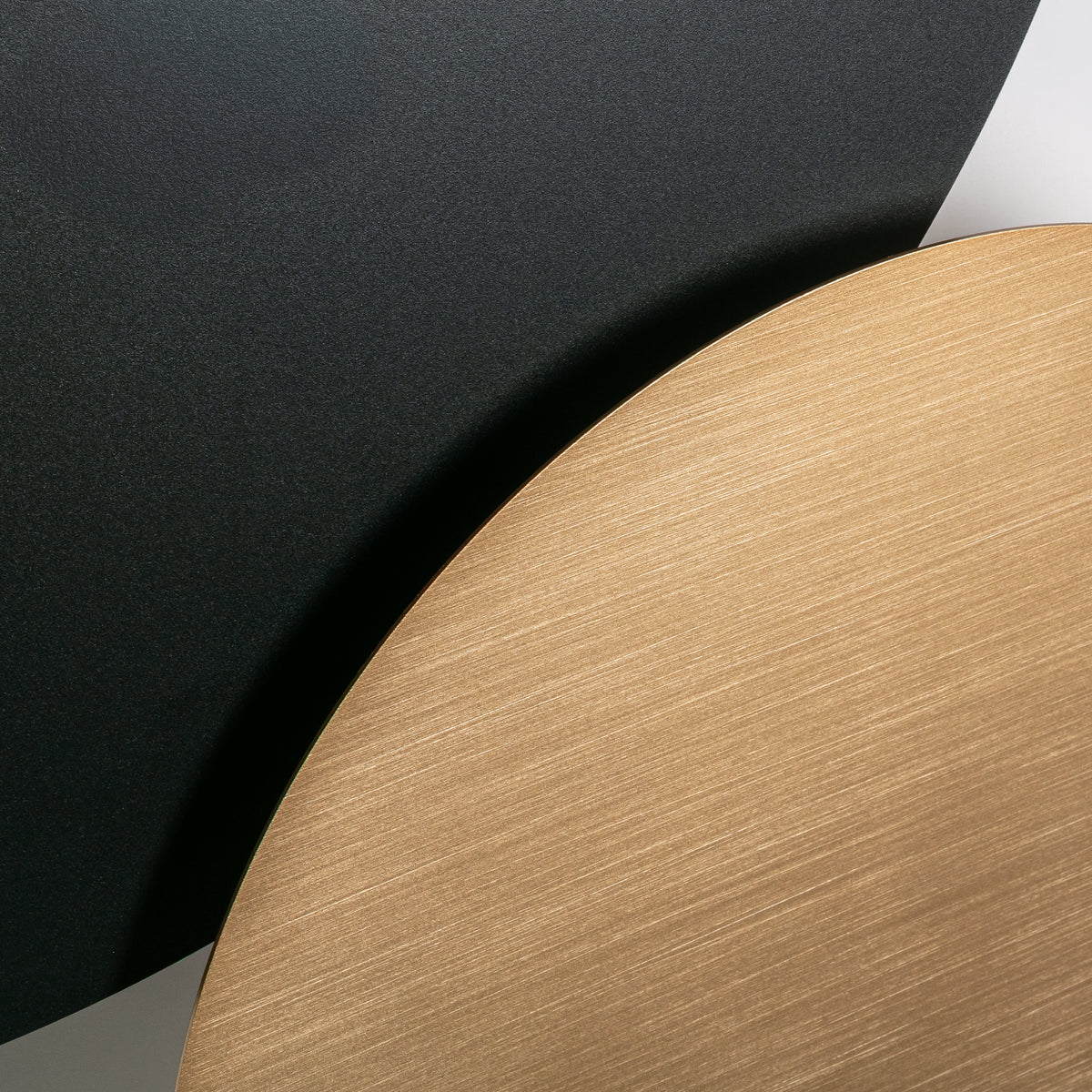 Détail de la surface dorée brossée et du disque noir mat superposés