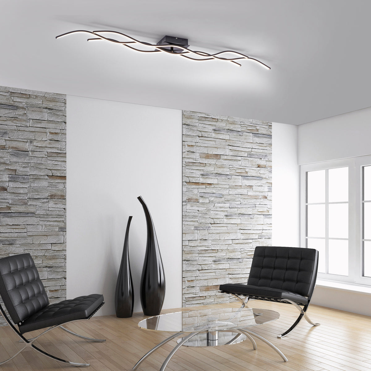 Mise en ambiance dans un salon moderne avec murs en pierre et fauteuils noirs