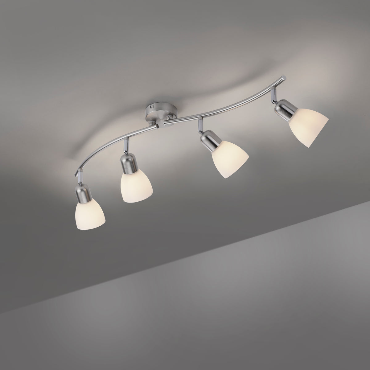Vue en contre-plongée du plafonnier fixé au plafond avec ses quatre verres éclairés.
