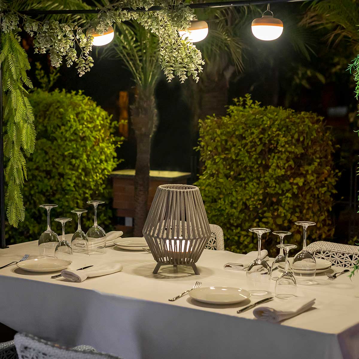 Mise en ambiance nocturne sur table dressée, lampe au centre du repas