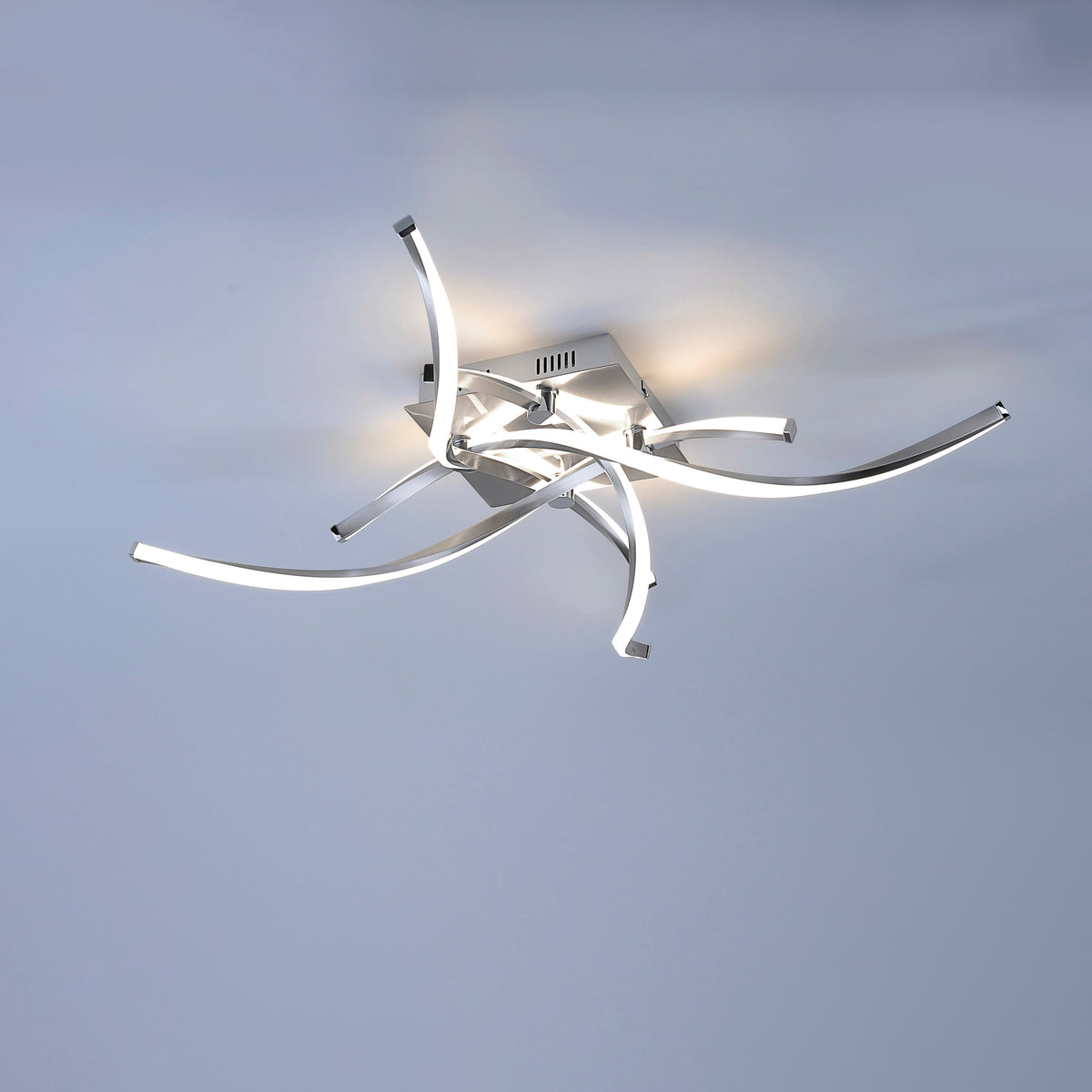 Plafonnier allumé diffusant une lumière chaude au plafond dans une pièce sombre.