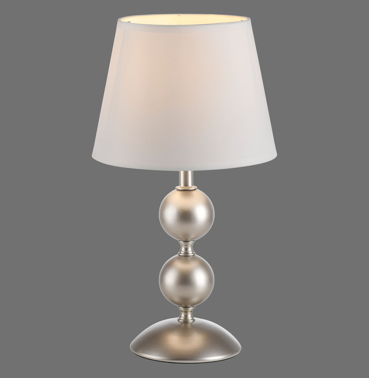 Lampe à poser de face sur fond gris, abat-jour crème et base métal champagne