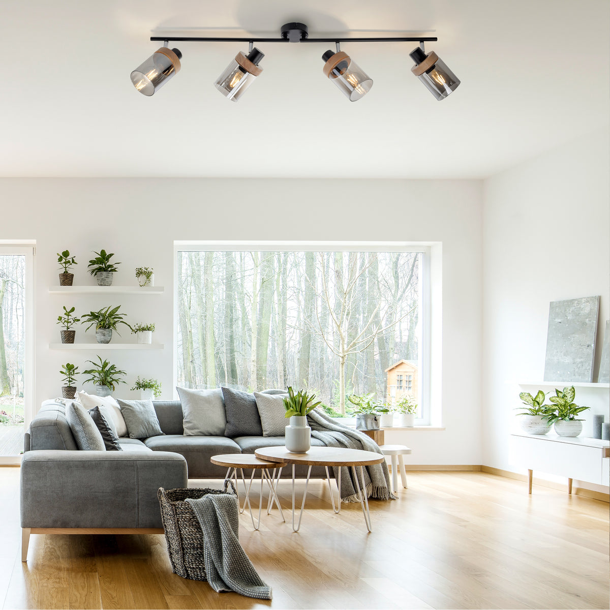 Mise en ambiance dans un salon lumineux, plafonnier allumé au-dessus d'un canapé gris