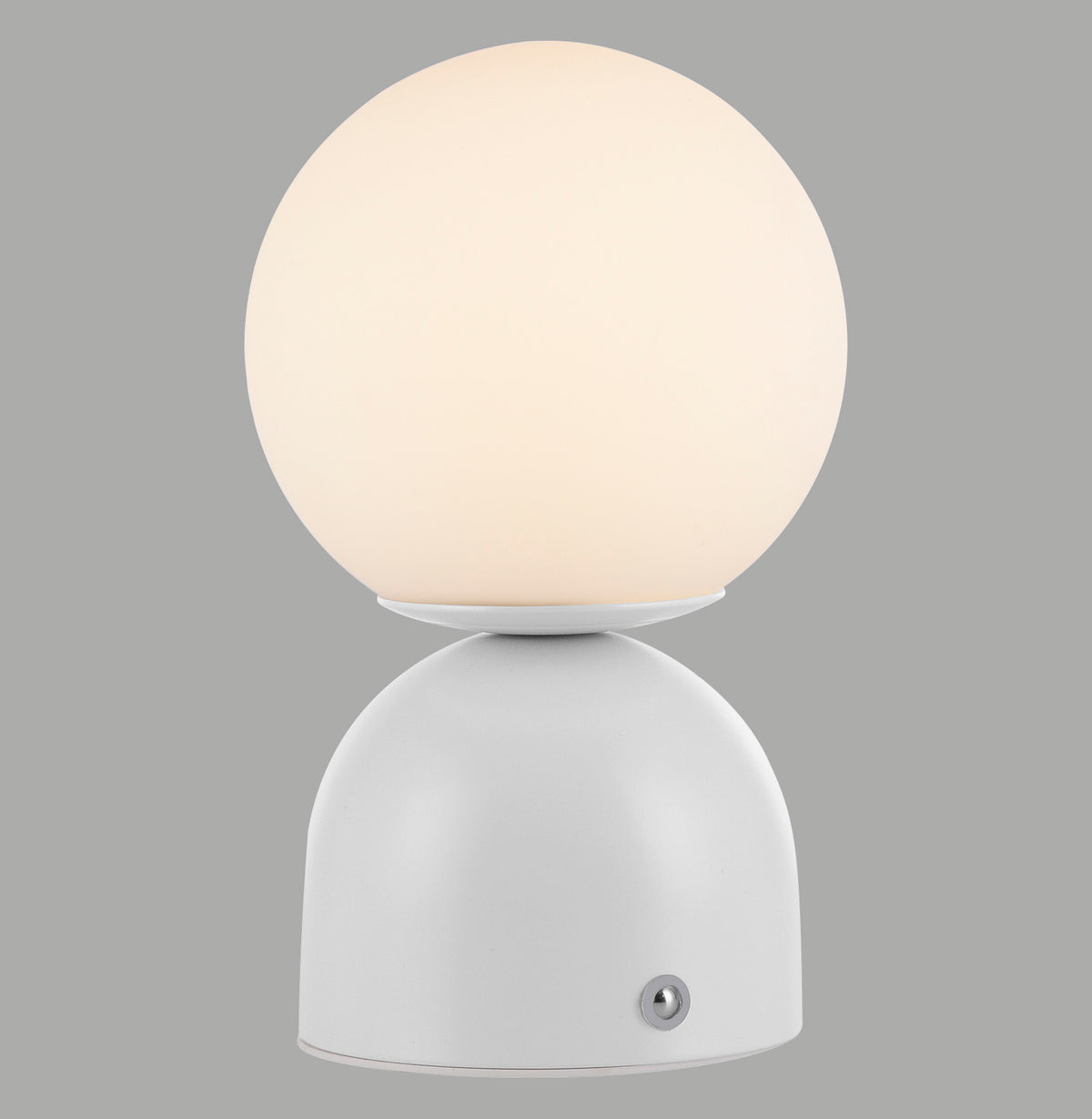 Lampe à poser blanche avec globe sphérique allumé sur socle arrondi, fond gris neutre.