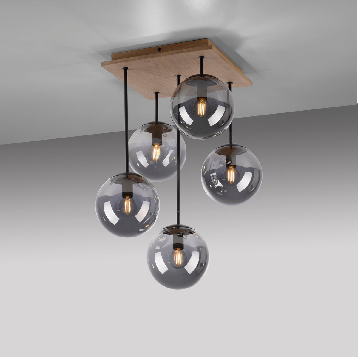 Vue en angle du luminaire fixé au plafond avec plaque en bois et tiges noires.