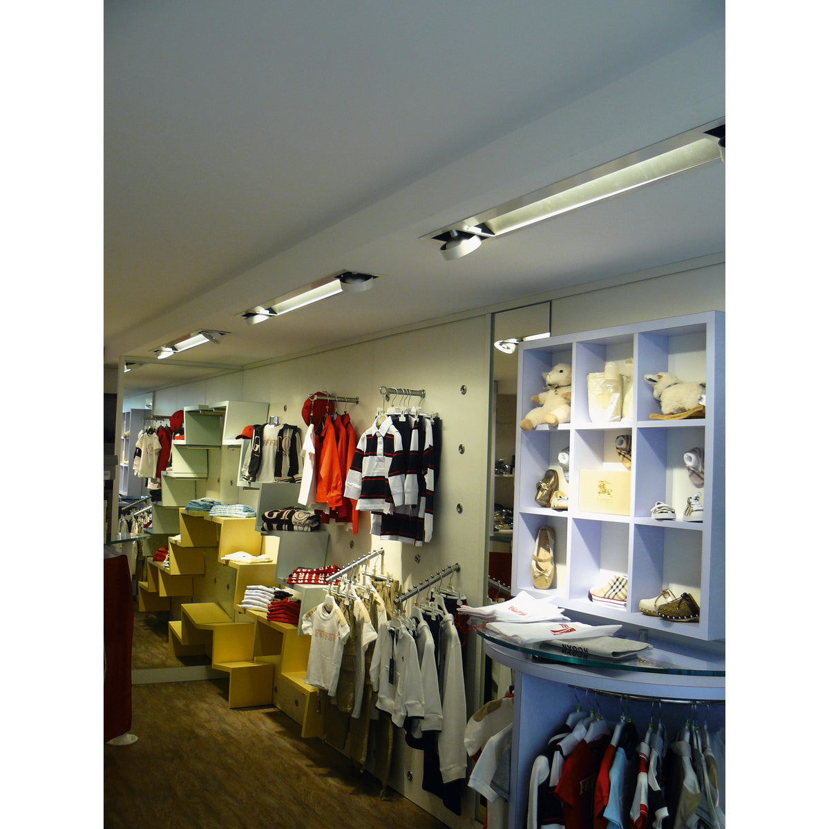 Vue d’ambiance d’un magasin de vêtements avec éclairage encastré au plafond.