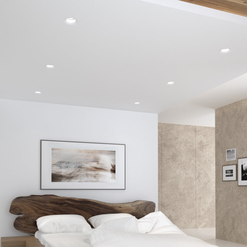 Mise en ambiance dans une chambre, plusieurs spots encastrés allumés au plafond blanc.