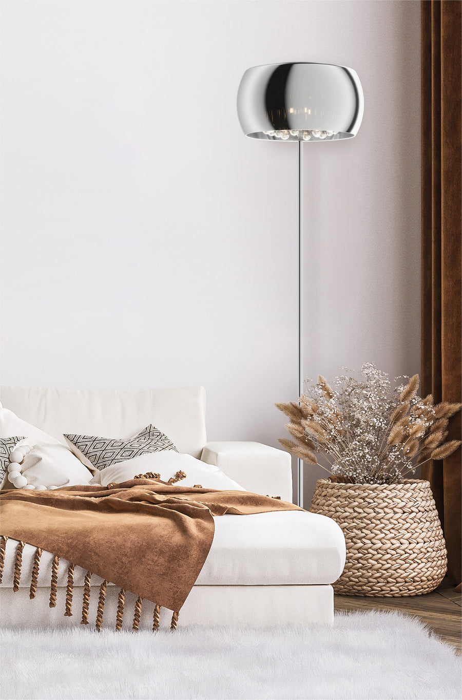Lampadaire allumé dans une chambre, canapé blanc, plaid marron et panier tressé.