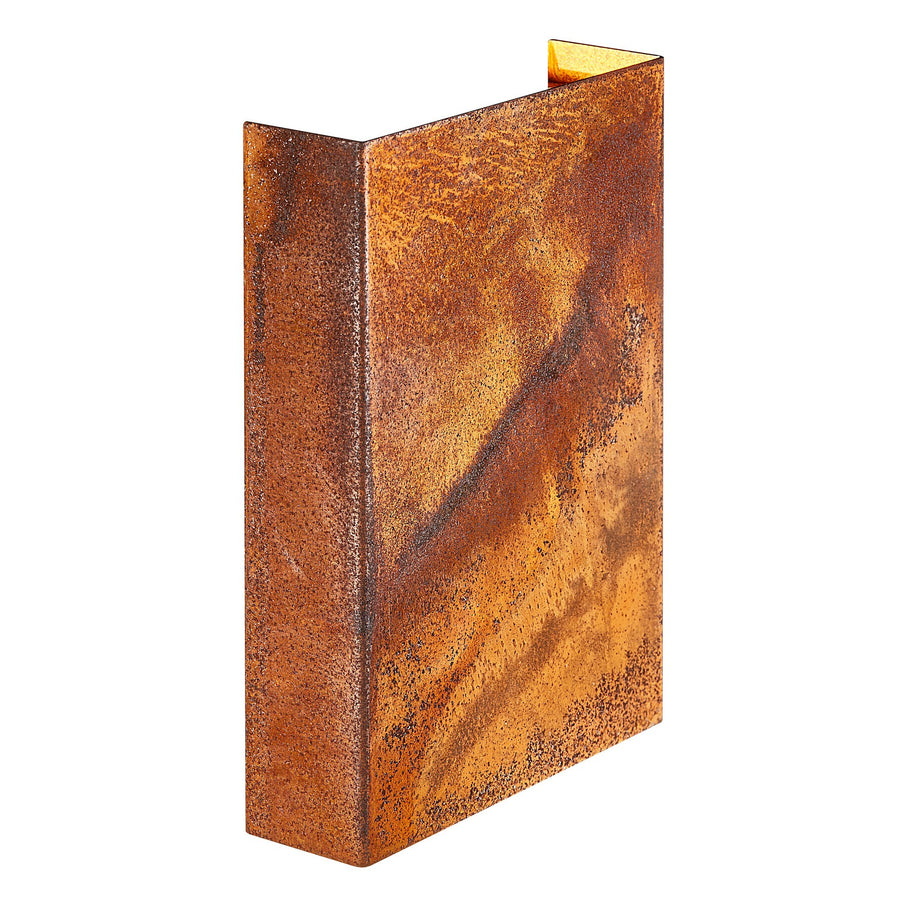 Vue de trois quarts du luminaire mural rectangulaire en acier corten, ouverture lumineuse en haut.