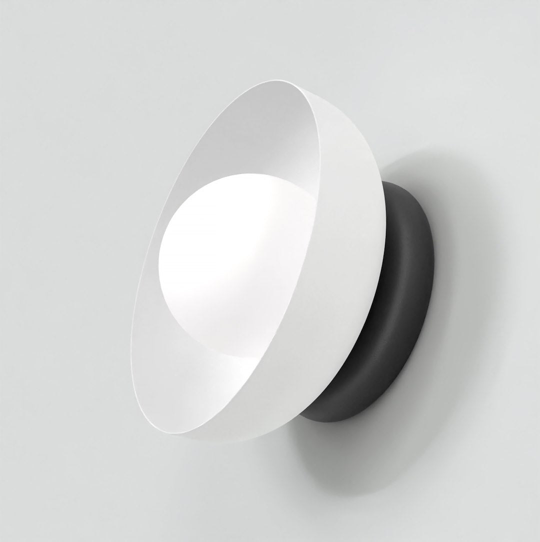 Luminaire mural vu de trois quarts avec sa coque blanche et son support noir