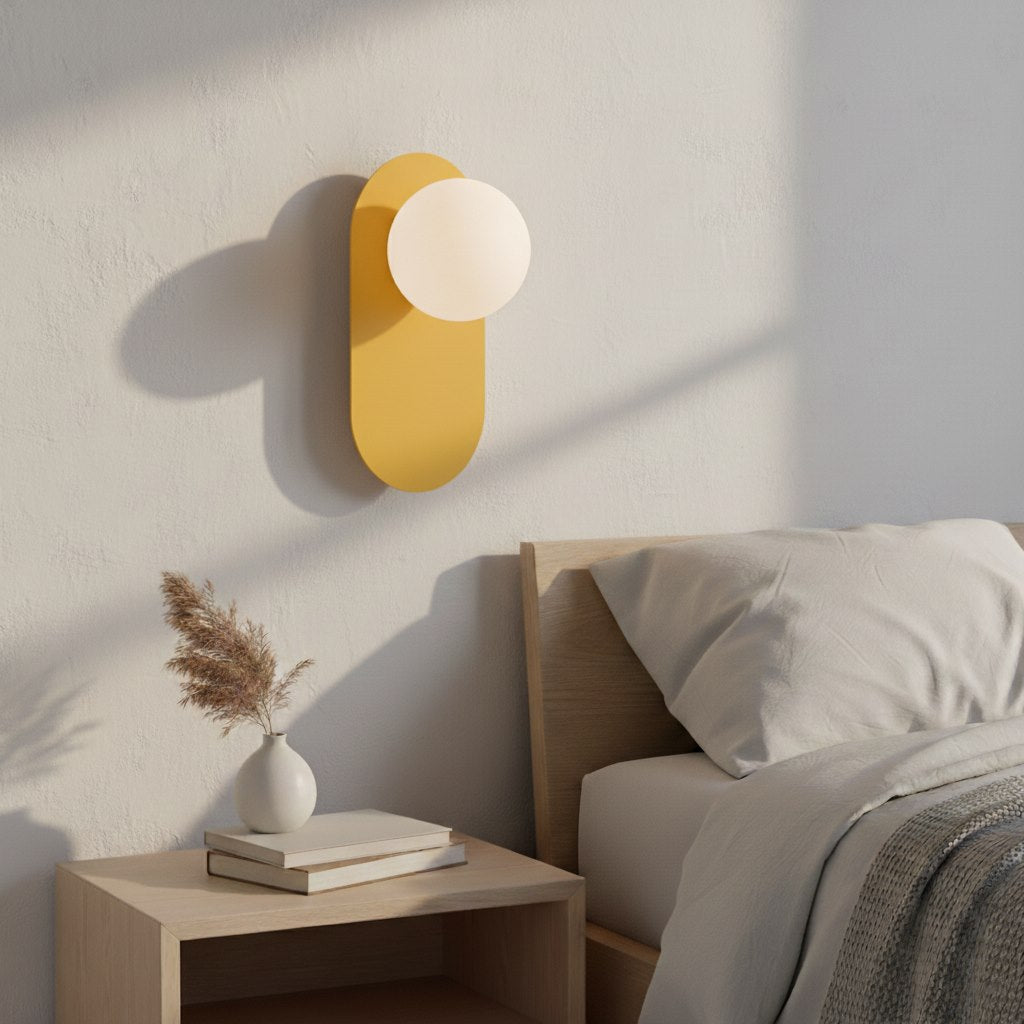 Mise en ambiance dans une chambre, applique allumée au-dessus d'une table de chevet.