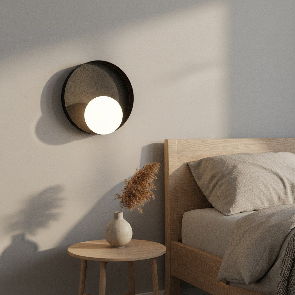 Mise en ambiance dans une chambre, applique allumée au-dessus d'une table de chevet