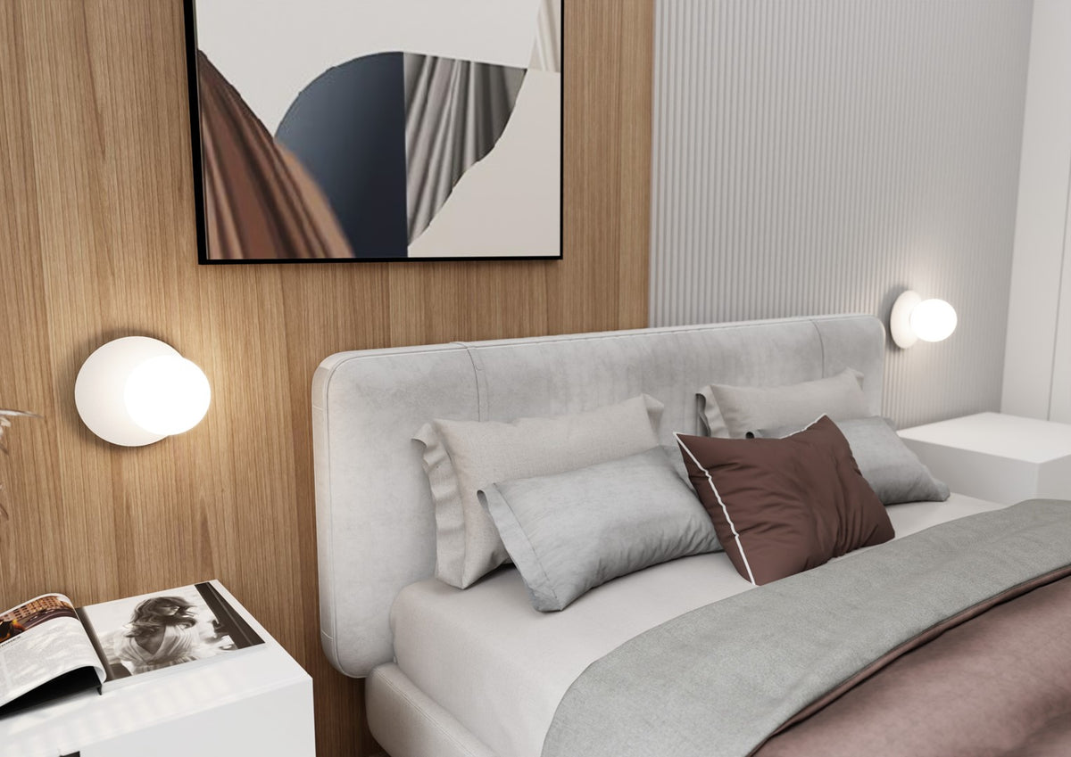 Chambre complète avec deux appliques murales allumées de chaque côté du lit