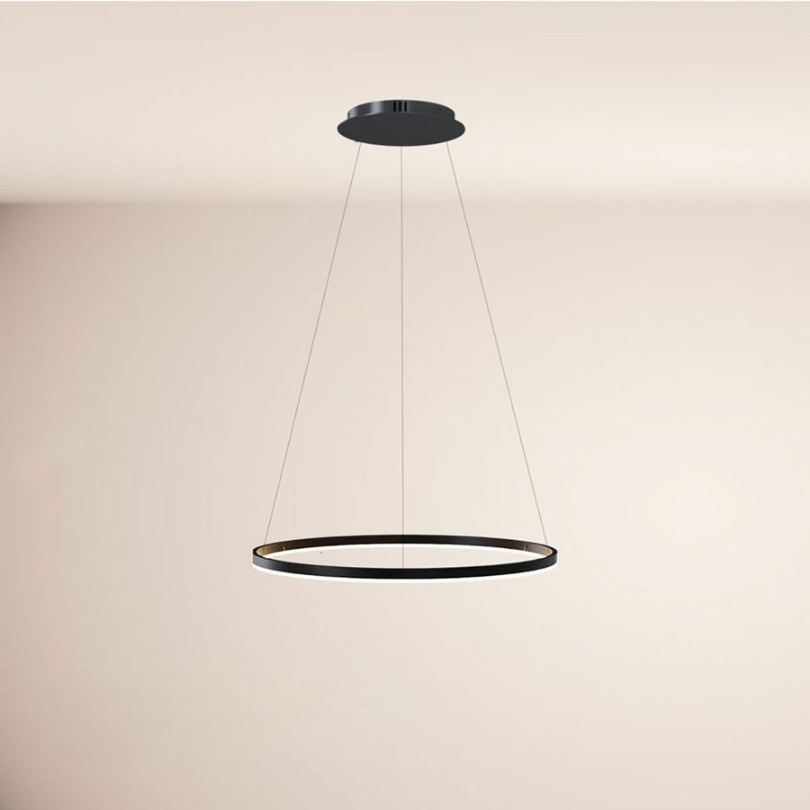 Anneau noir unique suspendu à trois câbles sur fond de mur beige uni