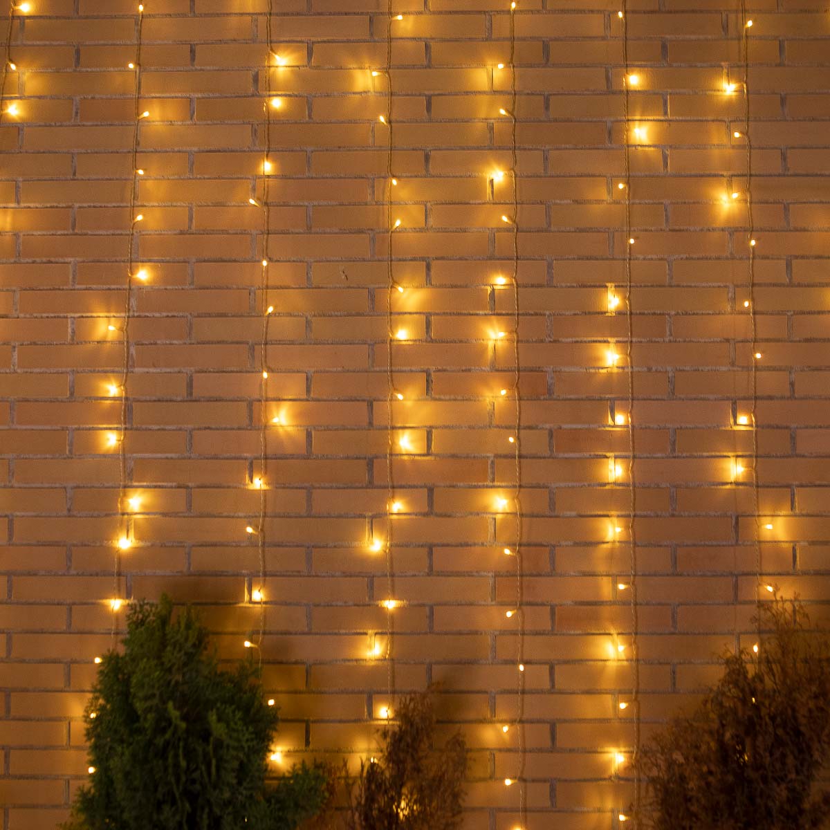 Vue d'ensemble du rideau lumineux déployé sur un mur de briques