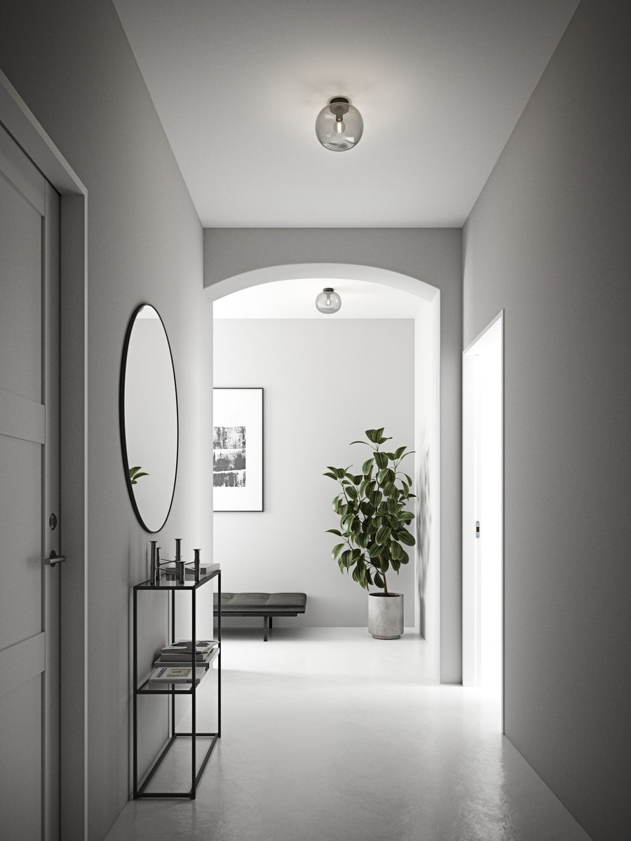 Mise en ambiance d'un couloir clair avec plafonnier en verre transparent éclairant le passage.