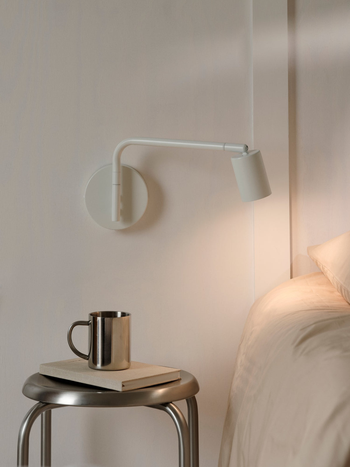 Mise en ambiance chaleureuse au-dessus d'un tabouret avec mug et lit