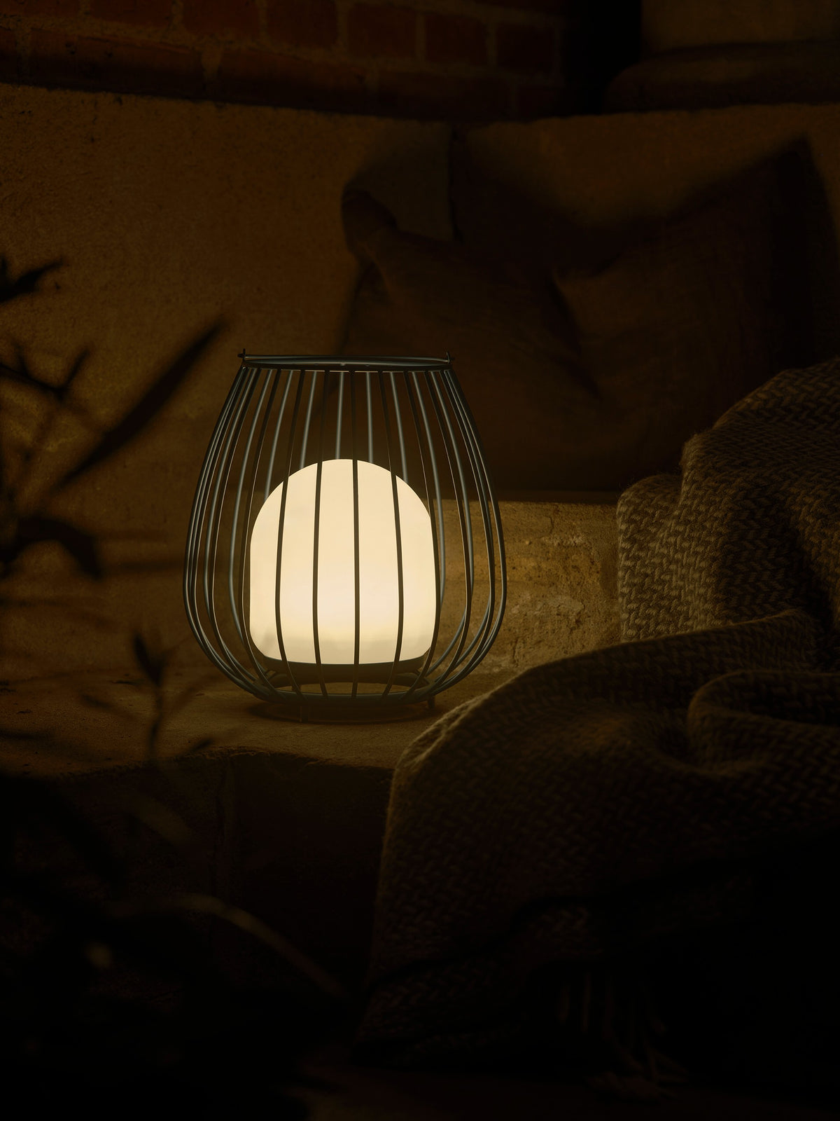 Lampe allumée posée sur une marche en pierre, ambiance nocturne chaleureuse