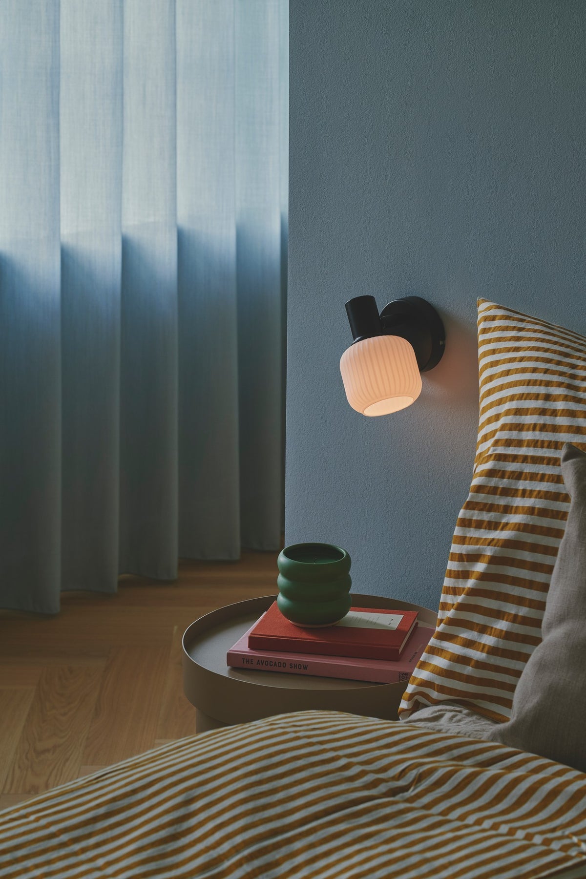 Mise en ambiance dans une chambre, près d'un lit à coussins rayés jaunes