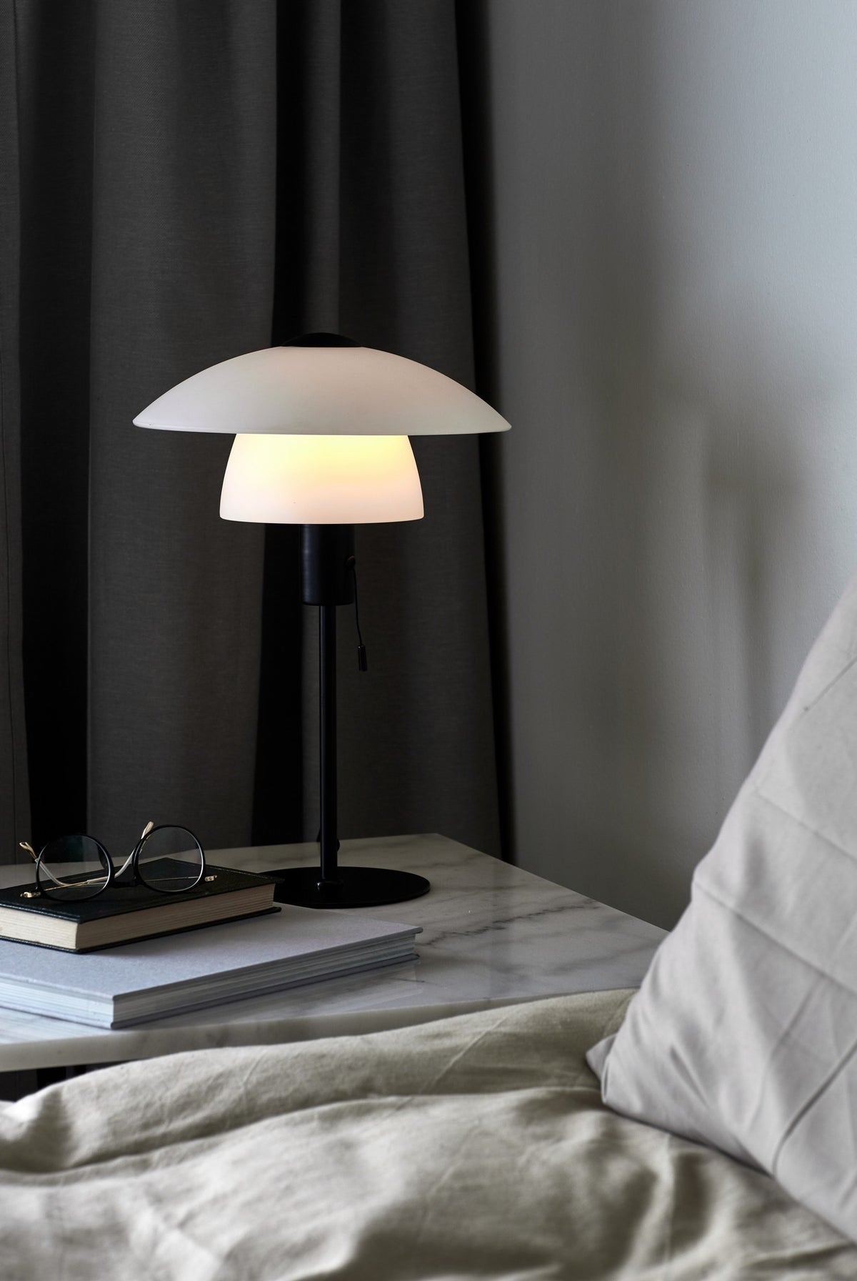 Mise en ambiance nocturne sur une table de chevet en marbre, près du lit