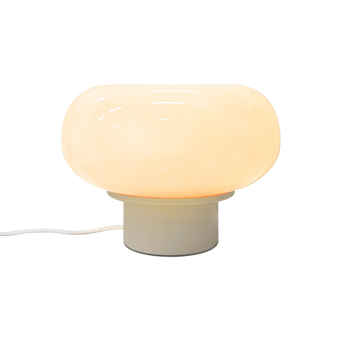 Lampe allumée de face, abat-jour en verre beige et base cylindrique, fil visible